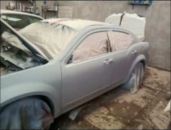 Auto cubierto y protegido durante proceso de pintura