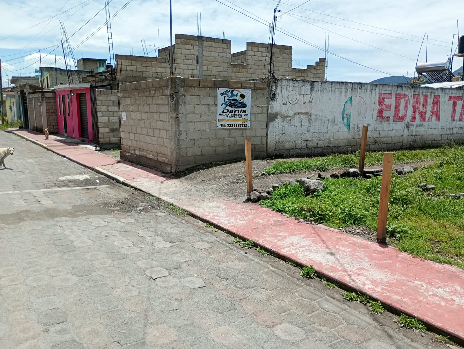 Entrada del Taller Danis señalizada sobre la barda de la calle